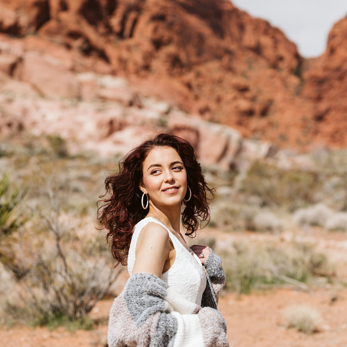Person smiling while walking outside in desert.